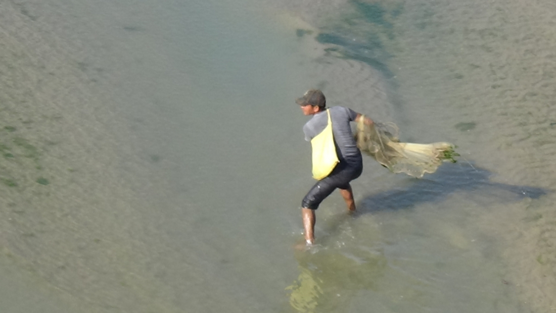 धनगढी उपमहानगरपालिका ३ का रामलाल राना मोहना नदीमा माछा मार्न जाल हान्दै 