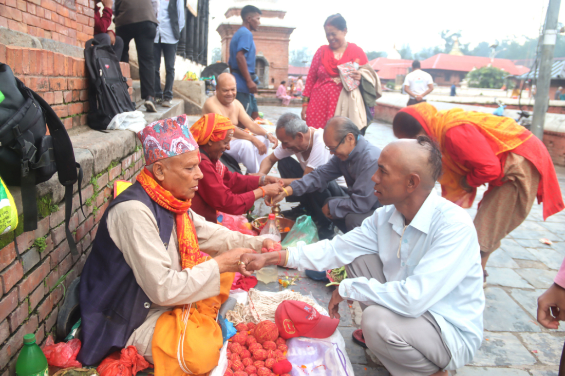 पुरोहितबाट डोरो बाँध्दै सर्वसाधारण